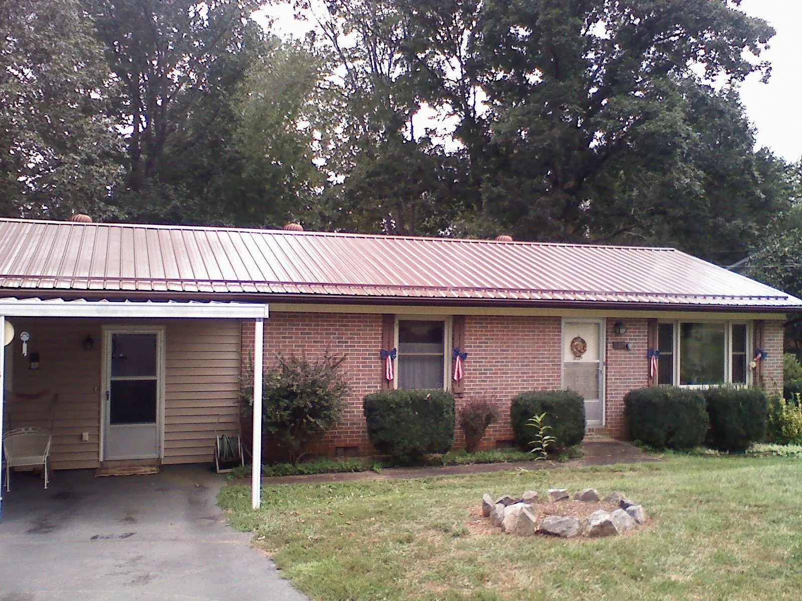 Bronze metal roof and carport on a brick ranch home — Roof Repair work by our crew in Oldsmar